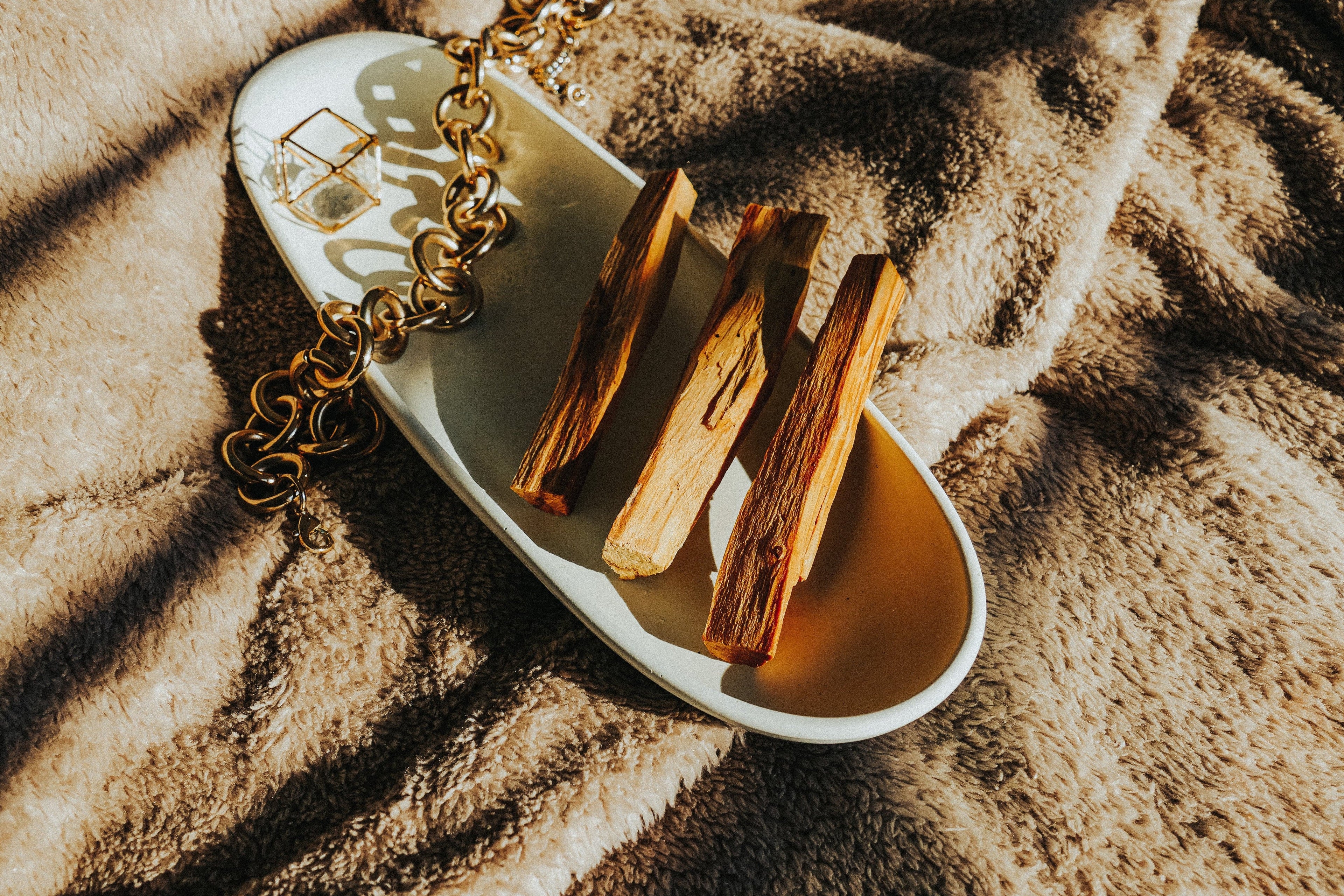 Sakally Palo Santo sticks on ceramic dish over soft fabric, natural incense wood for meditation, cleansing rituals, energy balance and relaxation