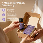 Sakally palo santo essential oil in an open gift box with an amber bottle, purple packaging, and shredded paper filling